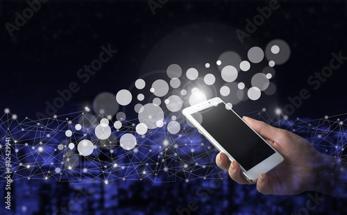 Innovative, and global network connection, Data exchanges. Hand hold white smartphone with digital hologram data circles sign on city dark blurred back. Innovation, big data.