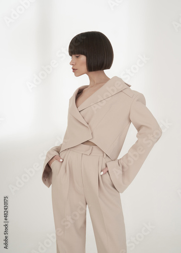 Fotografía Beautiful brunette with graphic bob haircut wear beige fashion pantsuit