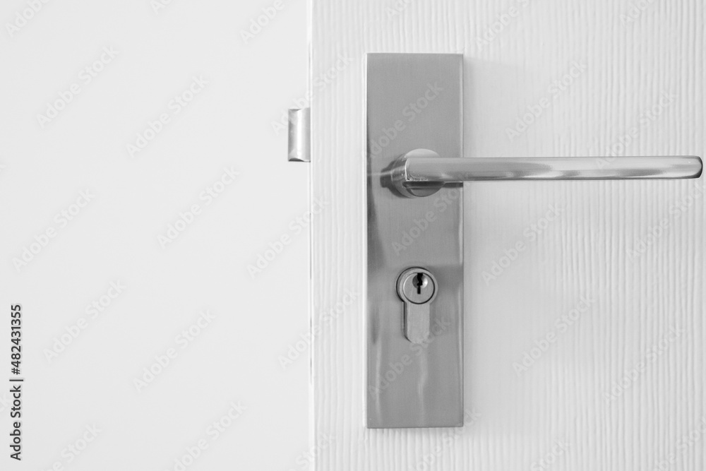 Modern door handle with keyhole on white door Modern door handle with keyhole on white door