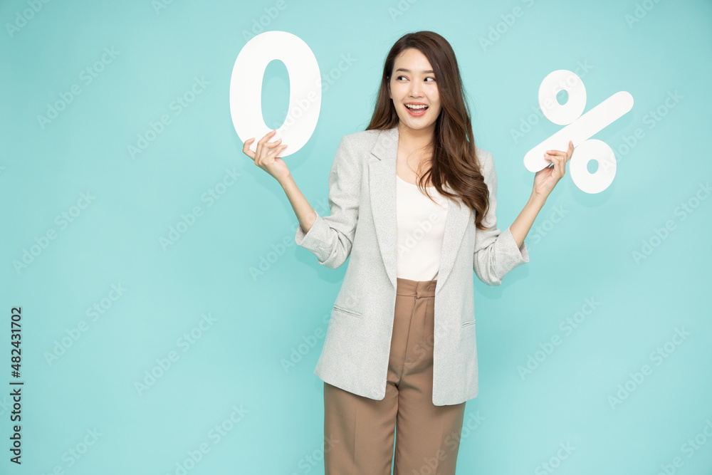 Portrait of Asian business woman standing and holding 0% number or zero percent isolated over green background Portrait of Asian business woman standing and holding 0% number or zero percent isolated over green background
