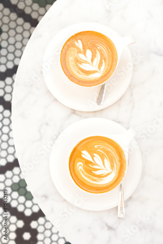 Cups of cappuccino on the white marble table in a modern cafe. Time out, coffee, luxury living, friends meeting concept. Place for text