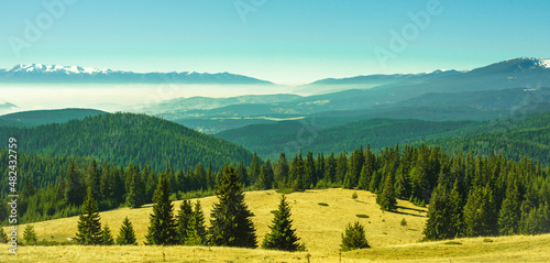 View from the side of Lake Belmeken to the Rila mountains and the peaks of the Pirin mountains in the fog