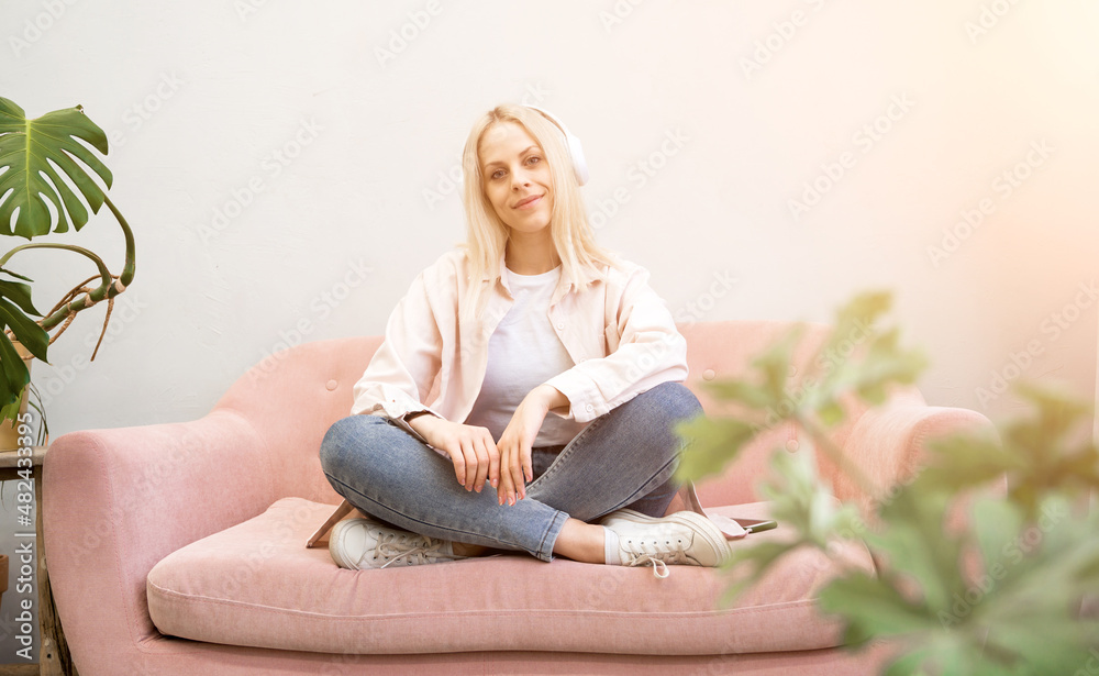 Attractive young blonde woman lying on the couch listeting to music. Relaxing concept
Attractive young blonde woman lying on the couch listeting to music. Relaxing concept