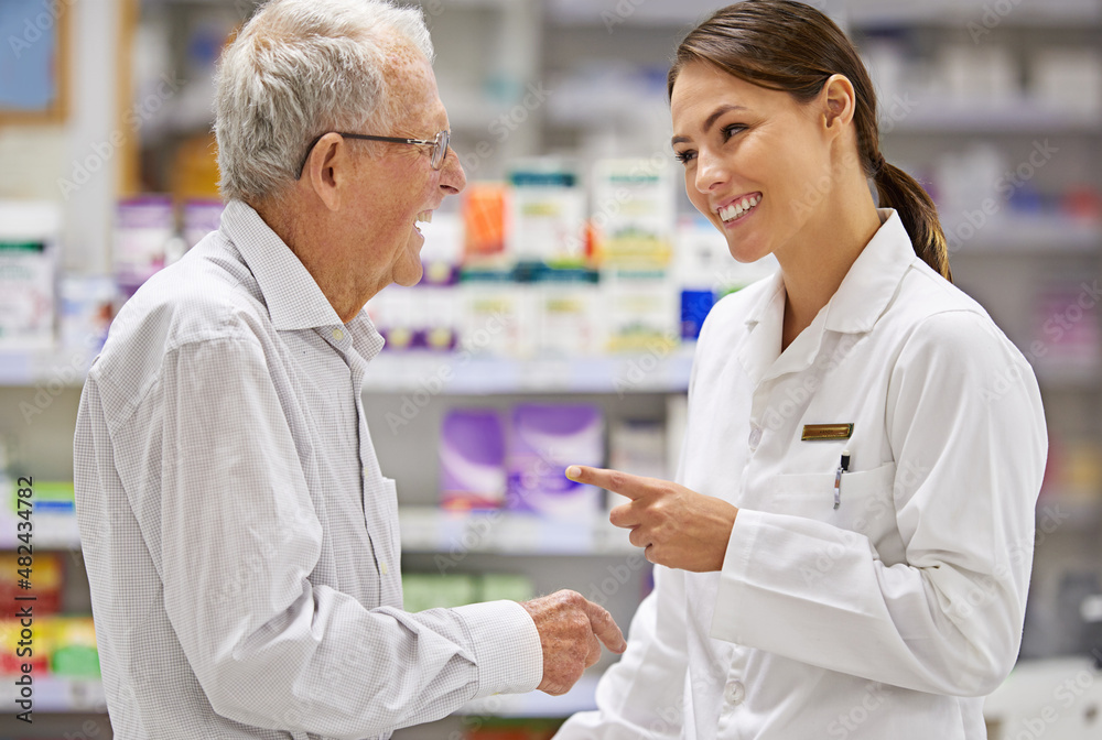 Treating her clients with care. Shot of a young pharmacist helping an elderly customer.