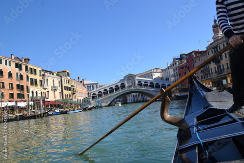 canal in venice, italy, with old buildings on the side, in a gondola ride, in blue tones, in the blue sky, reflection in the water