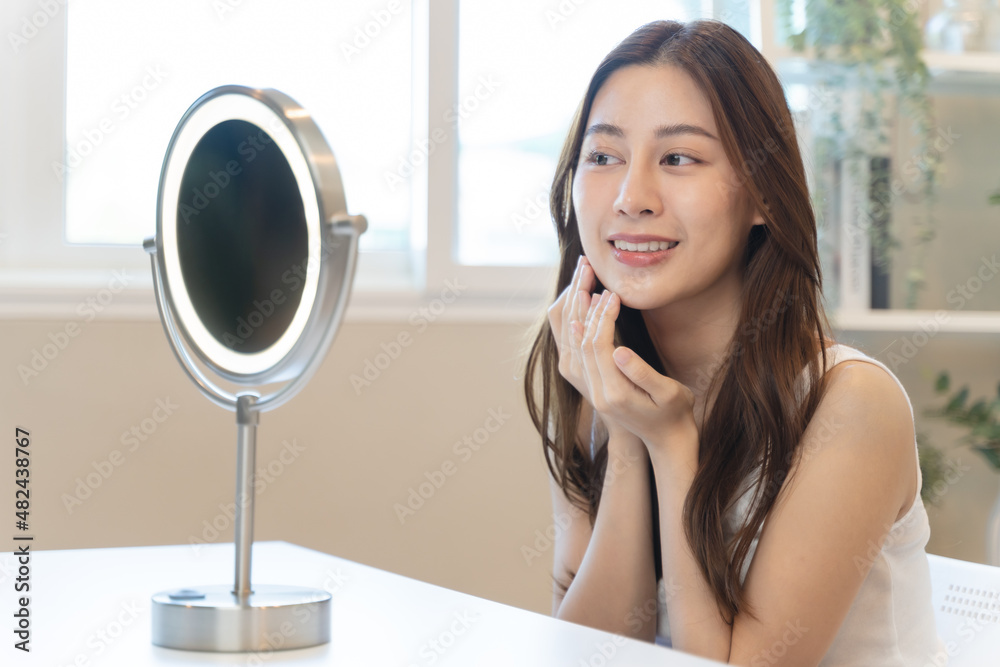Close up young beautiful asian woman looking at mirror at home Close up young beautiful asian woman looking at mirror at home