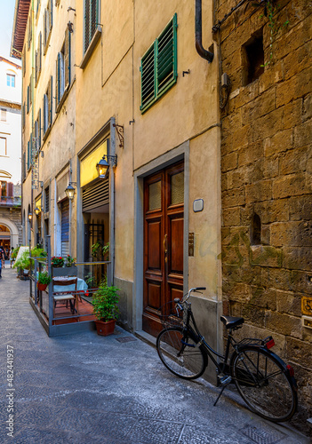 View of narrow street with tables of old trattoria in Florence, Tuscany, Italy. Architecture and landmark of Florence. Cityscape of Florence