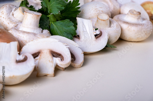 Close-up background of whole and sliced champignons with other cooking ingredients. Selective focus. Copy space.