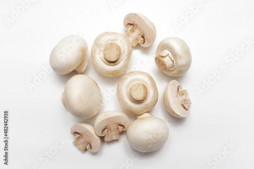 White Champignon Mushrooms on white Background. Raw mushrooms ready for cooking. Flat lay. Food concept.