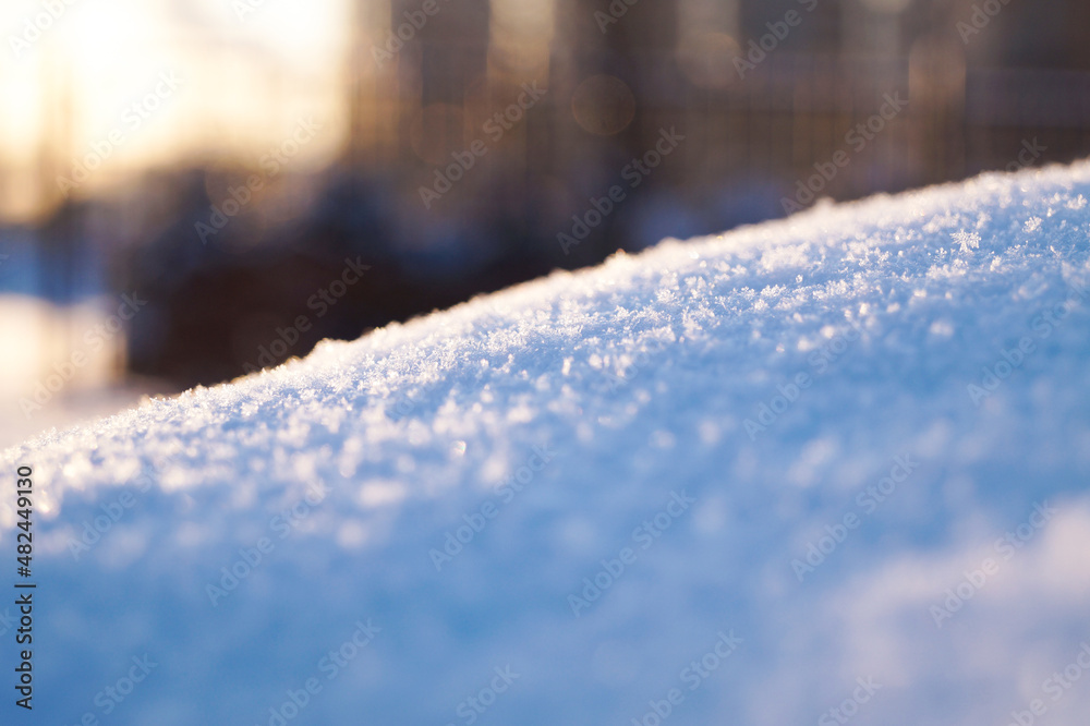 Fresh thick layer of snow close-up. Winter landscape with a blurry background. Sun rays. Fresh thick layer of snow close-up. Winter landscape with a blurry background. Sun rays.