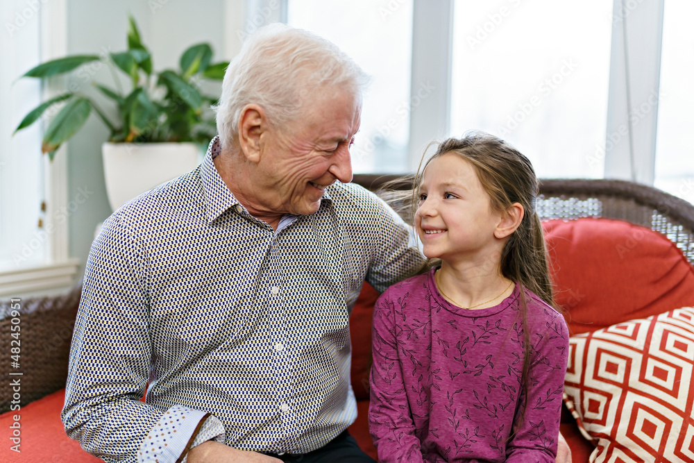 grandpa and little granddaughter having great time on sofa at home grandpa and little granddaughter having great time on sofa at home