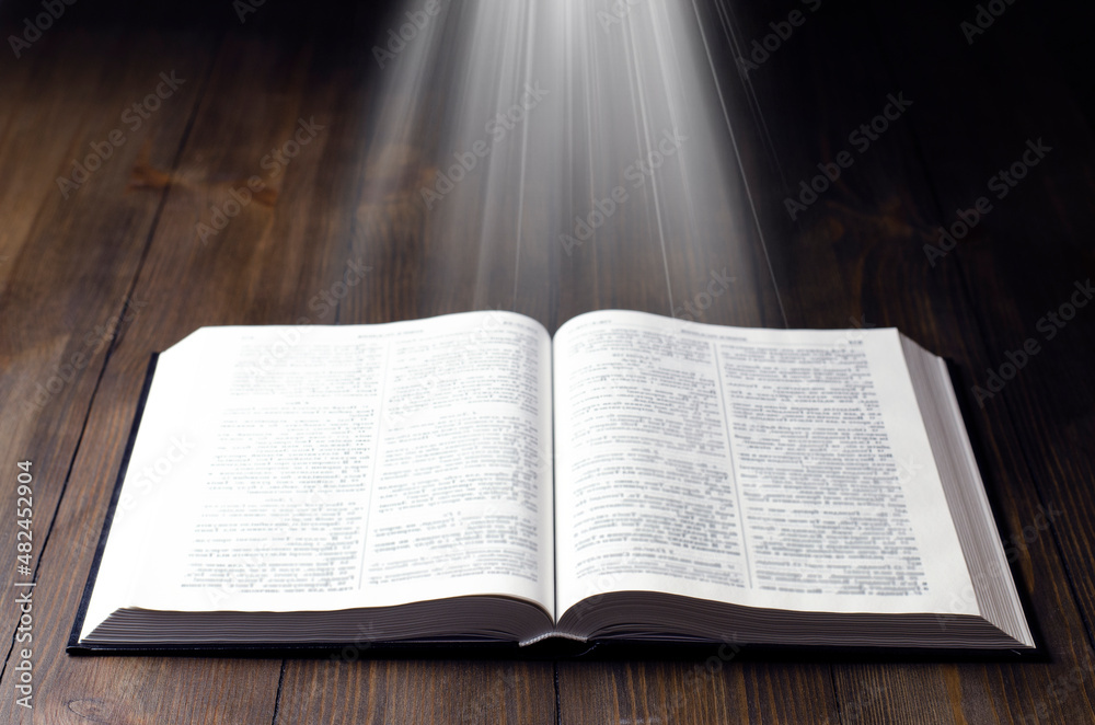 Fototapeta premium Open Bible. Open book. Light from a book. Old antique book. Magic, fairy tale.