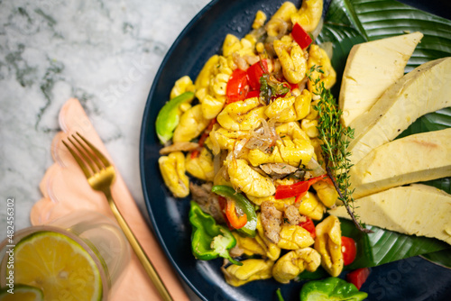 Quadro su tela Ackee and Saltfish with Breadfruit in Dark Blue Plate - Closeup