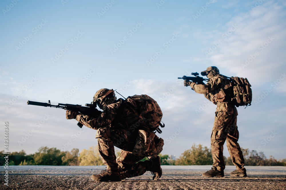 Military standing on the roof of a building with sniper rifles Military standing on the roof of a building with sniper rifles