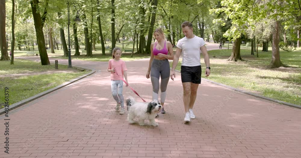 Sporty family walking with dog in a park Sporty family walking with dog in a park
