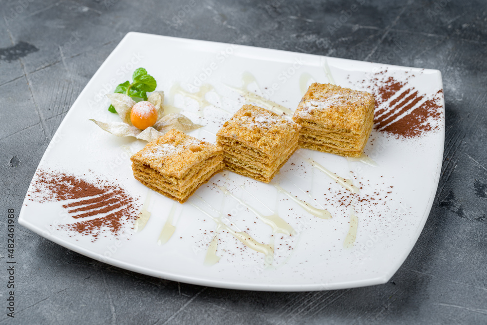 a piece of honey cake on plate on grey table a piece of honey cake on plate on grey table