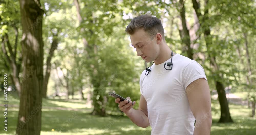Young man is resting and texting in the park Young man is resting and texting in the park