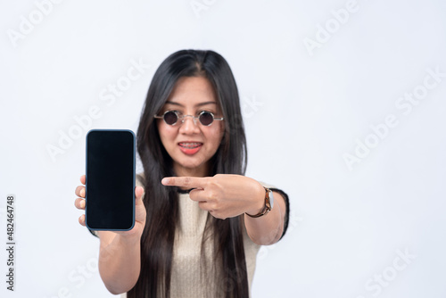 woman pointing finger at smartphone on white background focus on smartphone