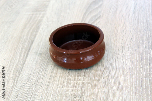 Romanian traditional ceramic pot from Horezu isolated on wood background photo
