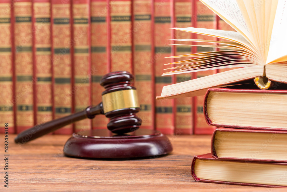 Legal Law and Justice concept - Open law book with a wooden judges gavel on table in a courtroom or law enforcement office. Copy space for text. Legal Law and Justice concept - Open law book with a wooden judges gavel on table in a courtroom or law enforcement office. Copy space for text.