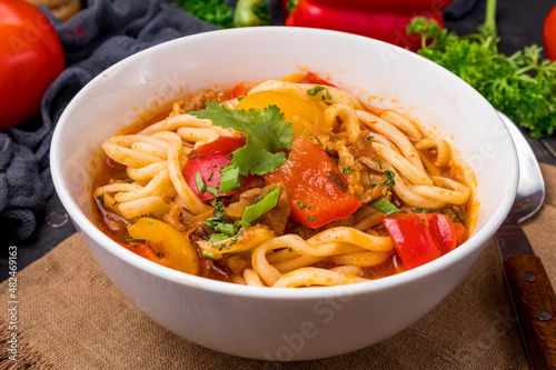 Lagman asian soup with meat, vegetables and noodles, dark table, uzbek cuisine