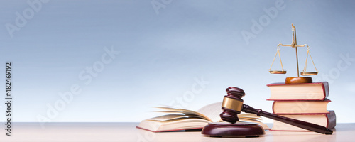Legal Law and Justice concept - Open law book with a wooden judges gavel on table in a courtroom or law enforcement office. Copy space for text. photo