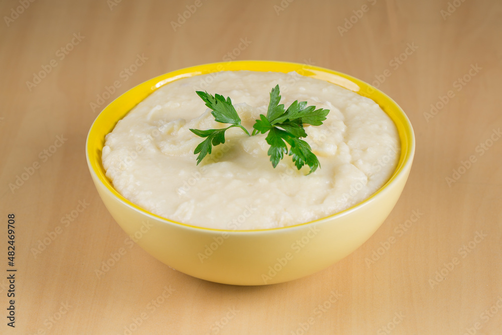 mashed potatoes in yellow bowl on wooden background mashed potatoes in yellow bowl on wooden background