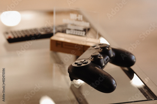 video game controller on glass table. gaming, technology and entertainment concept - blue gamepad controller on table