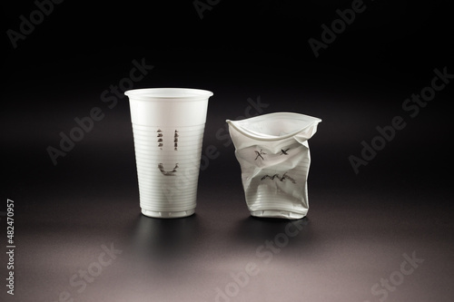 Fotografie Whole and crumpled disposable plastic cups with painted faces