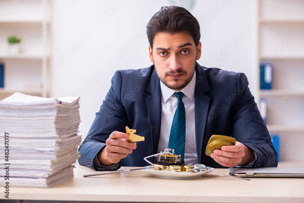 Young businessman employee eating alarm-clock Young businessman employee eating alarm-clock