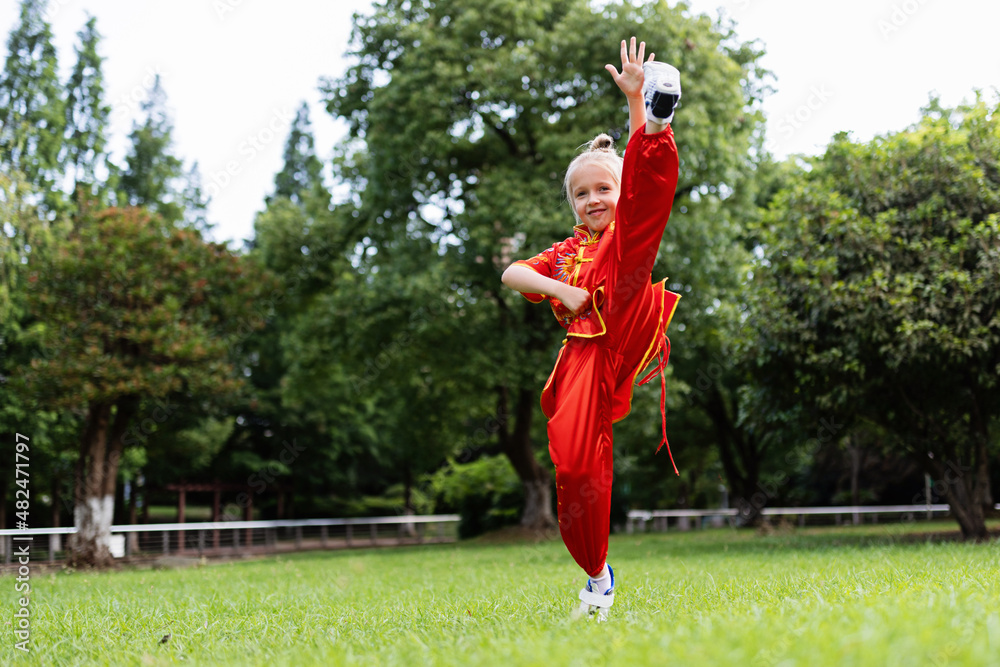 Cute little caucasian girl seven years old in red sport wushu uniform  exercising in park at summer day. Lifestyle portrait of kung fu fighter  child athlete foto de Stock | Adobe Stock