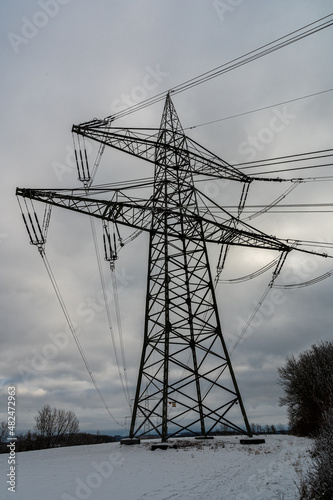 Hochspannungsmasten vor wolkigem Himmel