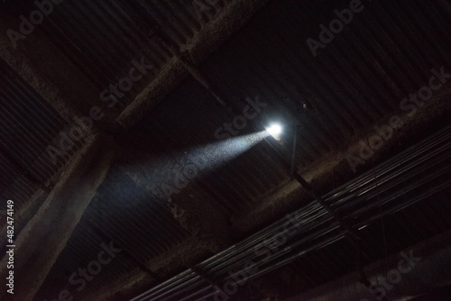Beam of light from a small pinhole hole in an abandoned building. Particulates dust