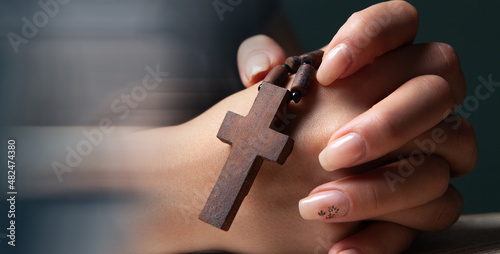 woman praying holding cross and arms crossed