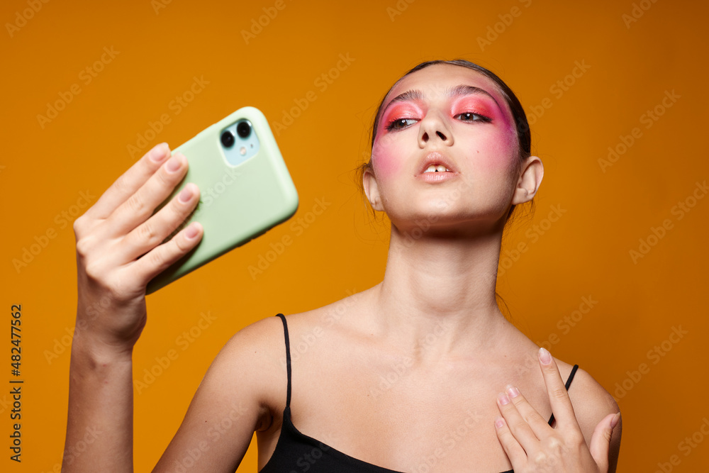 fashionable woman looks at the phone bright makeup posing fashion emotions isolated background unaltered fashionable woman looks at the phone bright makeup posing fashion emotions isolated background unaltered