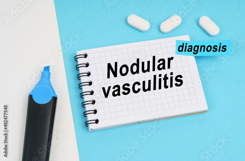 On a white and blue surface are pills, a marker and a notebook with the inscription - Nodular vasculitis photo