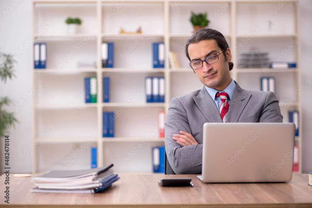 Young male employee sitting at workplace