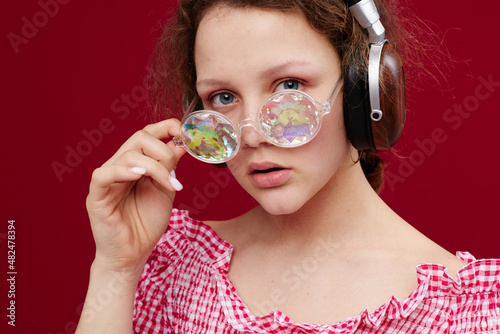 girl wearing headphones glasses with diamond close-up red background unaltered