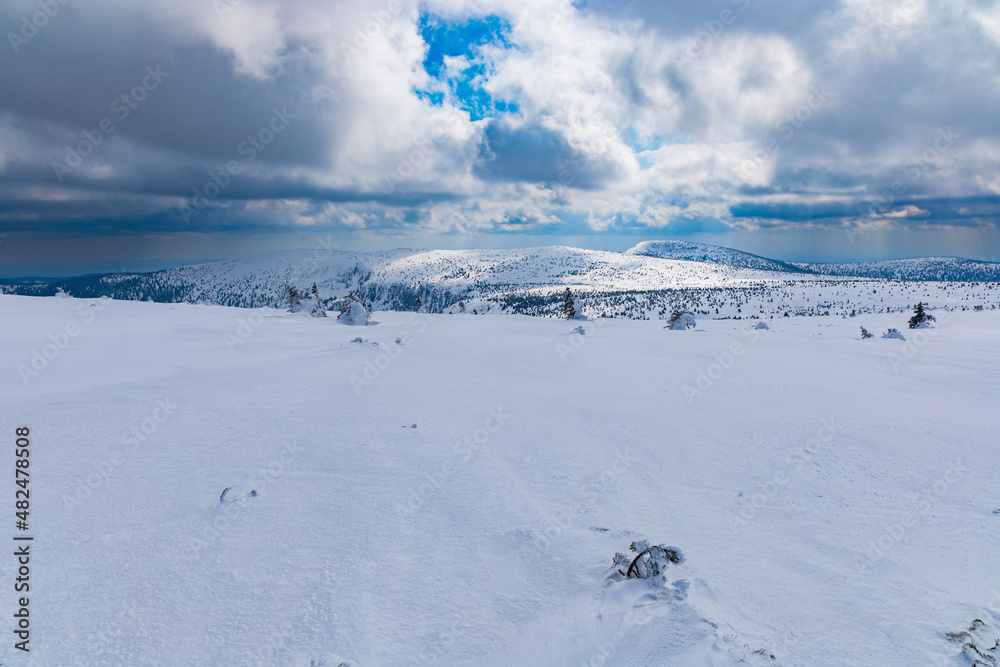 Snowy landscape of mountain trails and hills at cloudy morning