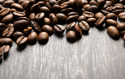 roasted coffee beans on a wooden background close up