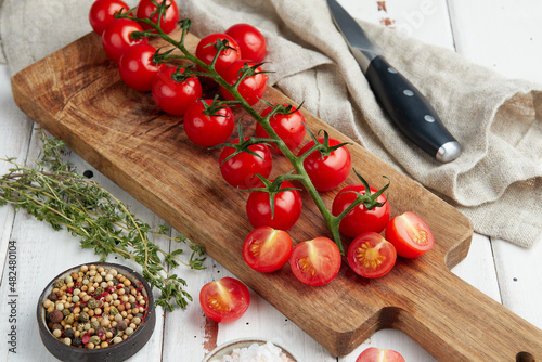 Fresh red cherry tomatoes on white wooden background