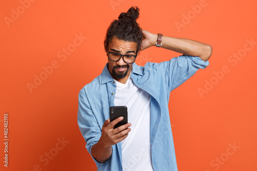 Shocked surprised young african american man looking at smartphone with stunned face expression