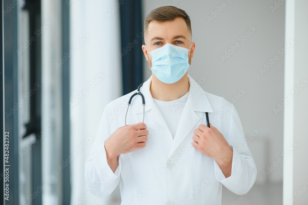 doctor man puts on a protective mask