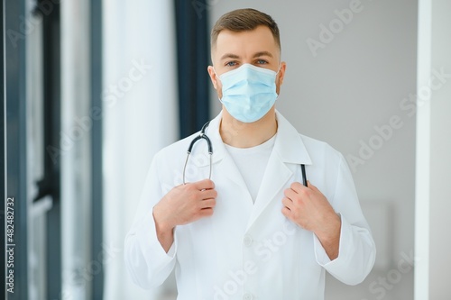 doctor man puts on a protective mask
