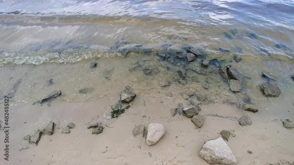 tidal waves hitting the beach with lot of stones on a shore. wide 4k video footage