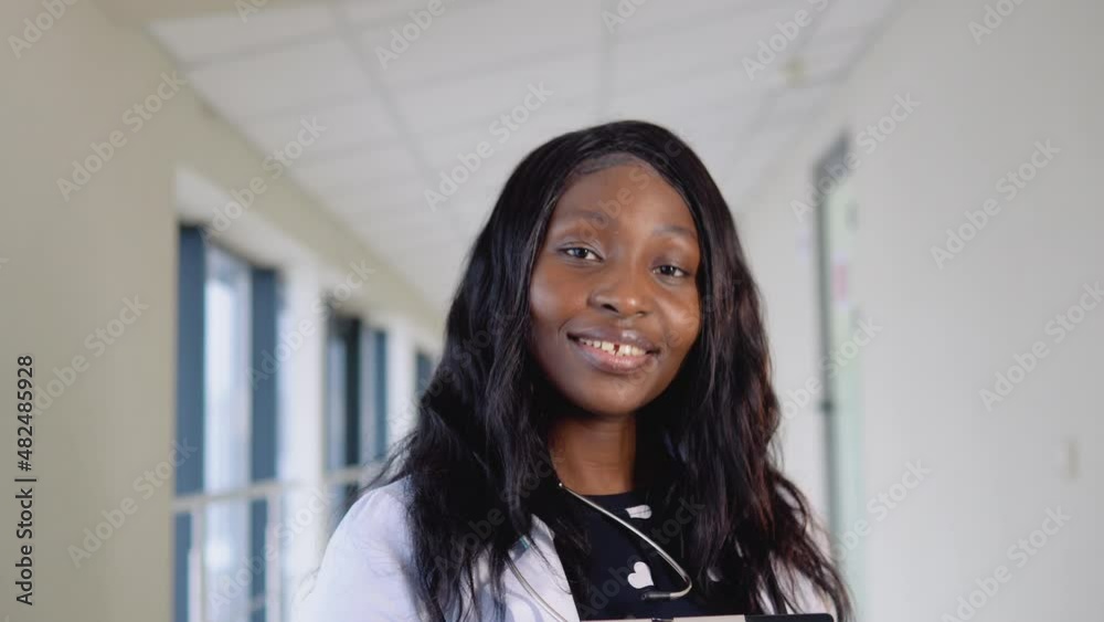 Portrait of african american female physician or intern professional general practitioner posing with stethoscope looking at camera in clinic Portrait of african american female physician or intern professional general practitioner posing with stethoscope looking at camera in clinic