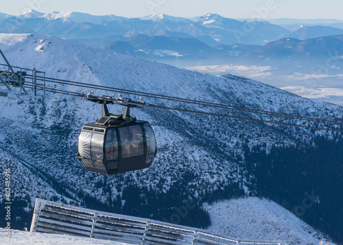 gondola ski lift in mountain ski resort, winter day, snowy spruce forest