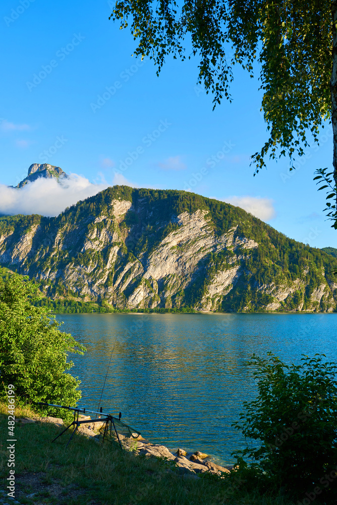 Fishing by the lake Mondsee in Alps mountains, Austria. Beautiful sunset landscape. 
