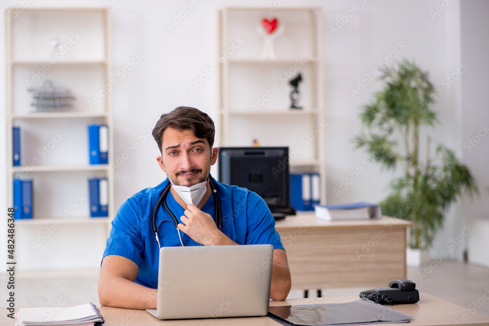 Young male doctor working in the clinic during pandemic Young male doctor working in the clinic during pandemic