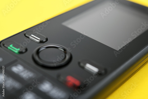 Retro mobile phone on a yellow background. 